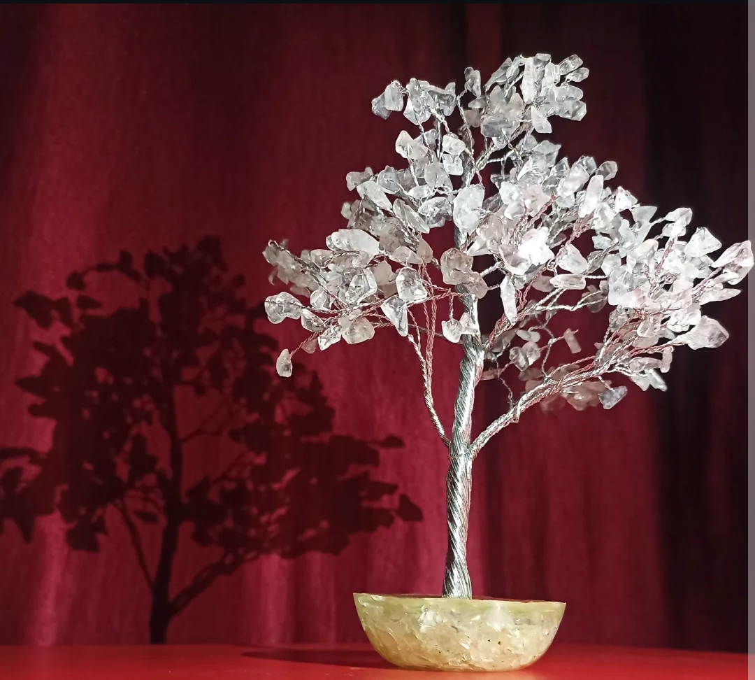 Clear quartz crystal tree glowing on a golden base